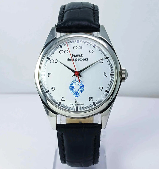 Wristwatch with black leather strap and white dial on a light gray background