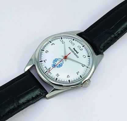 Wristwatch with black strap and white face on a light gray background