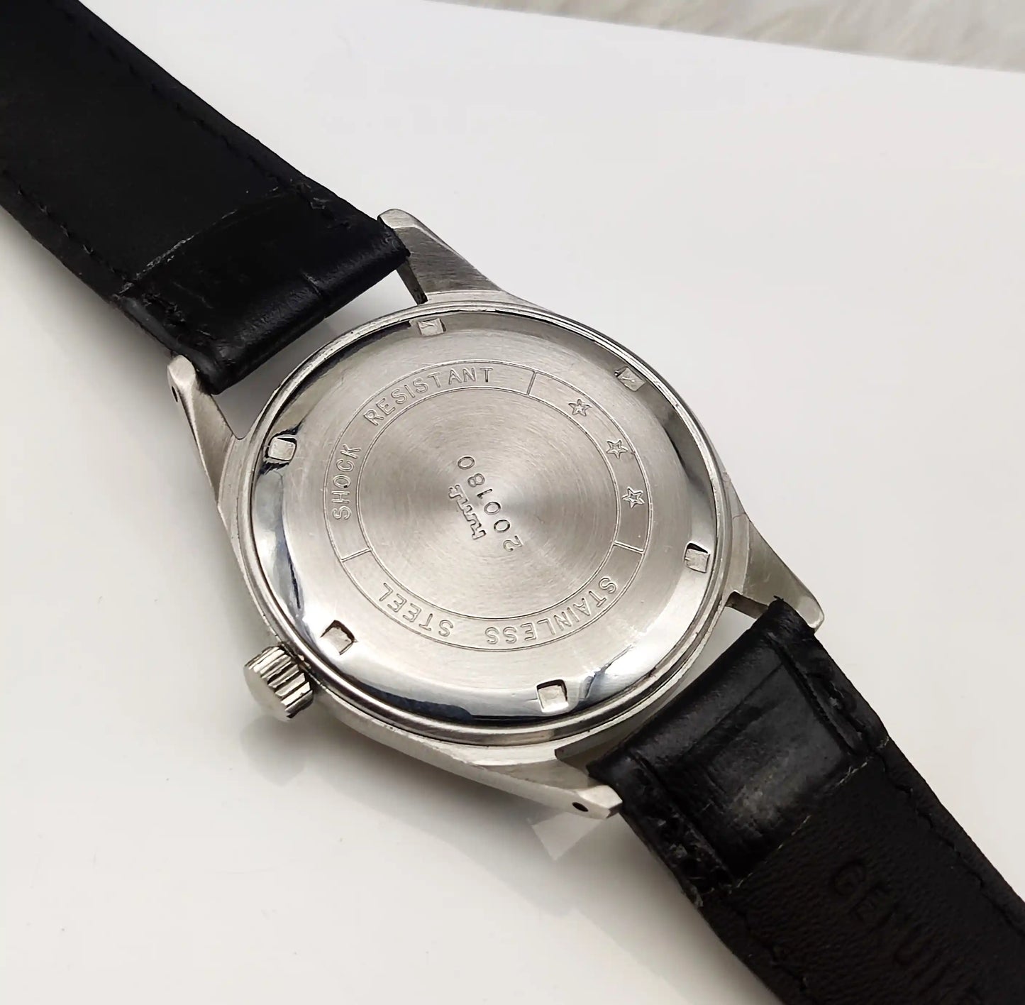 Wristwatch with black leather strap and silver case on a white background