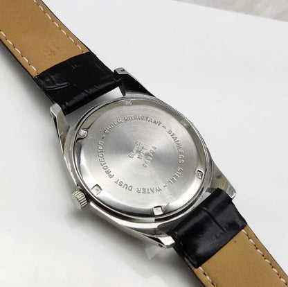 Close-up of a watch with a black strap and silver case on a white background
